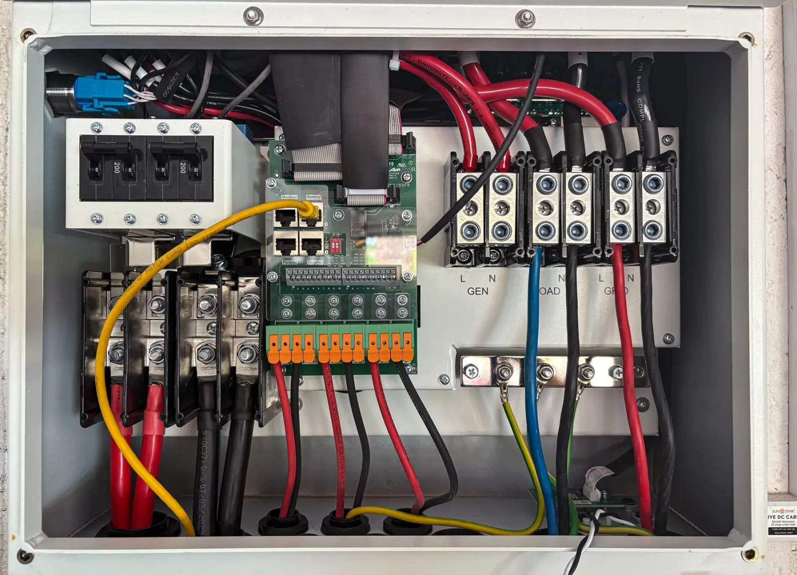 Kapağı açık elektrik panosunun içinde kablaj, klemensler ve şalterler